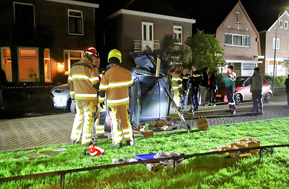 Auto op zijn kant op de Kwelkade