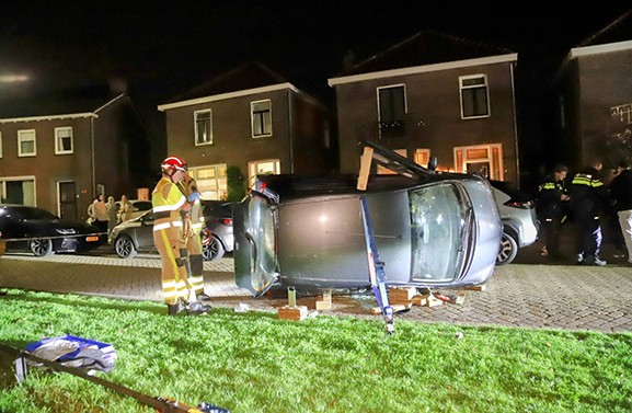Auto op zijn kant op de Kwelkade