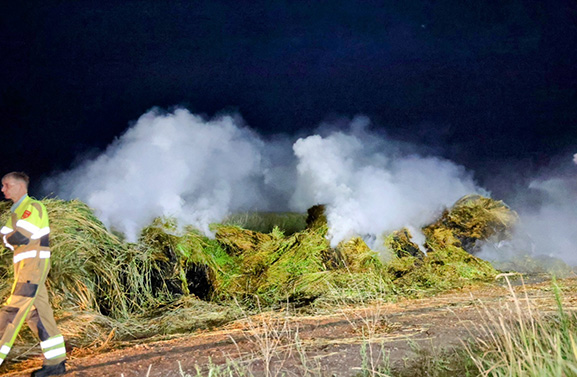 Grote berg met slootmaaisel in brand; veel rook en stankoverlast