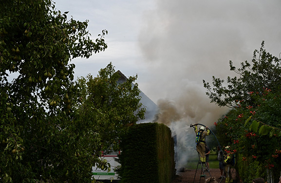 Buitenbrand aan een coniferenhaag; veel rookontwikkeling