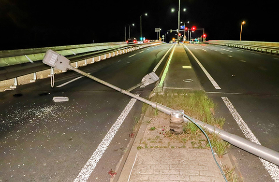 Auto ramt vluchtheuvel en rijdt lantaarnpaal uit de grond