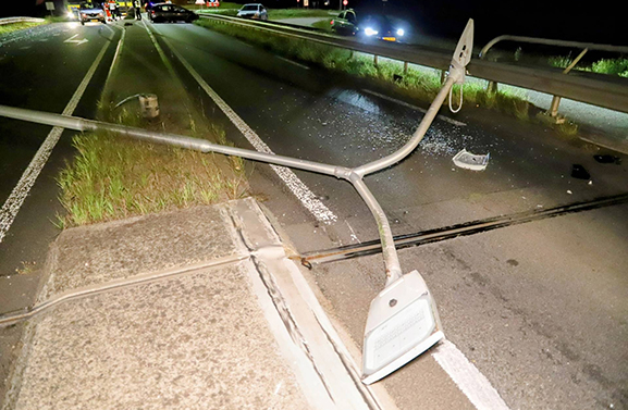 Auto ramt vluchtheuvel en rijdt lantaarnpaal uit de grond