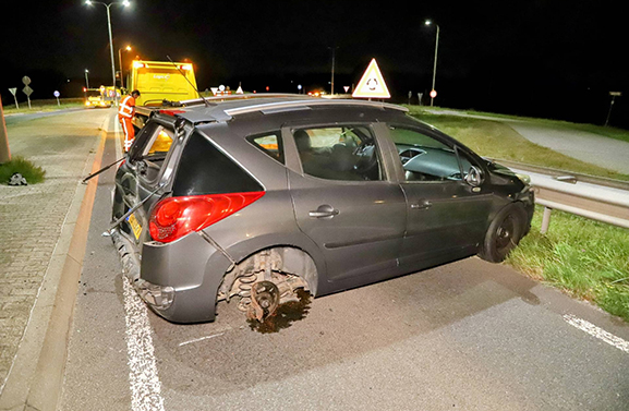 Auto ramt vluchtheuvel en rijdt lantaarnpaal uit de grond