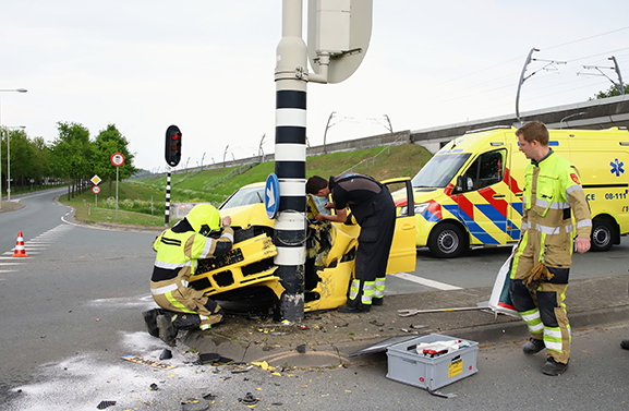 Grote schade bij botsing van gele auto tegen paal van verkeerslicht