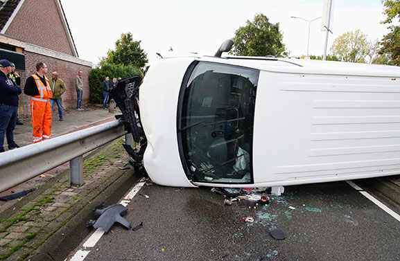 Bedrijfsbus op zijkant nadat bestuurder macht over het stuur verliest