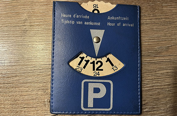Motoreigenaar loopt tegen de lamp met illegale blauwe parkeerschijf