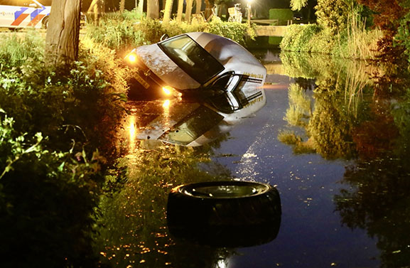 Botsing met balenpers, auto te water aan het Hoogeinde in Leerdam