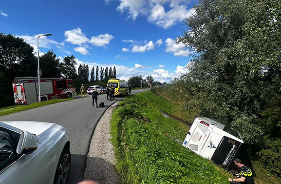 Touringcar belandt op zijkant onderaan de Diefdijk