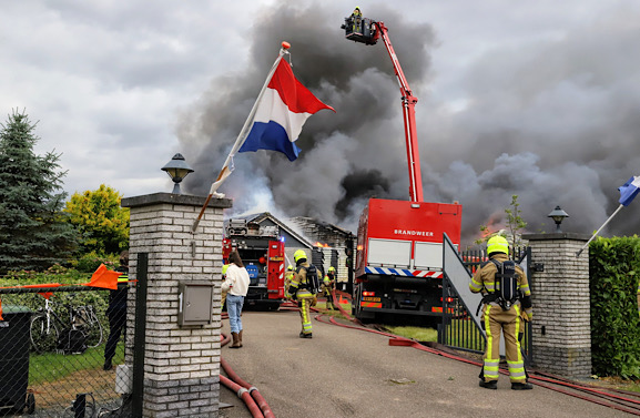 Stukjes zonnepaneel in weiland na grote brand in loods