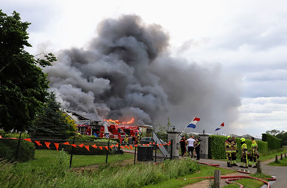 Stukjes zonnepaneel in weiland na grote brand in loods