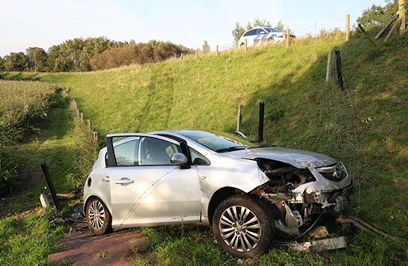 Auto rijdt van de dijk in Asperen