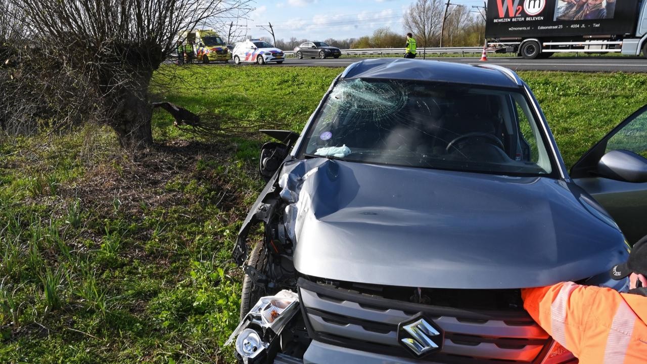 Auto ramt verkeersborden en boom langs A15 bij Gellicum